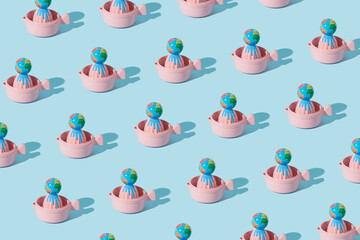 Creative pattern made of globe or planet earth squeezed on a pink lemon squeezer. Art direction  composition of global abuse of planet earth. Minimal awareness concept.