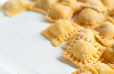 Fresh homemade italian pasta ravioli filled and stacked. Cooking process. Selective focus. Raw food with copyspace.