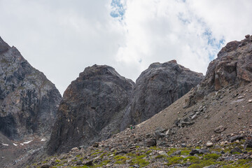 Scenic mountain landscape with two big stone bumps under cloudy sky. Beautiful mountain scenery with two large stone hills in cloudy weather. Awesome alpine view to high two rocky hills under clouds.