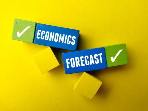 Top view colores wooden block with text ECONOMICS FORECAST on yellow background