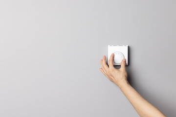 Woman Hand Adjusting or Turning On Off Wall Temperature Regulator Controller Button