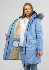 young woman in winter clothes on white background. Photo concept for advertising a down jacket