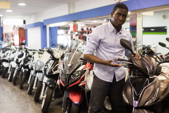 African american man is shopping and choosing new motobike in moto store. High quality photo