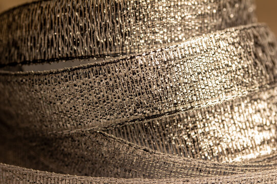 Defocused Full Frame Macro Abstract Texture Background View Of Shimmering Metallic Gold Fabric Ribbon
