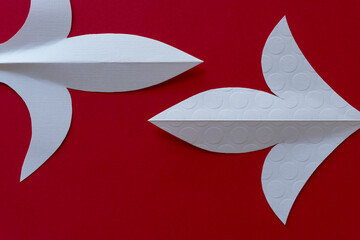 two traditional decorative paper shapes on red