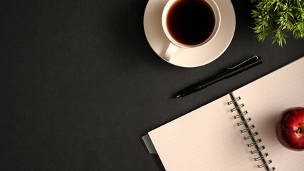 Simple hipster dark workspace with coffee cup, pen, notebook and copy space.