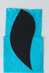 cut paper shape on textured blue paper