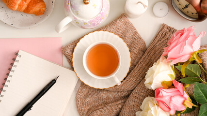 Feminine workspace concept, A notebook with a set of English afternoon tea