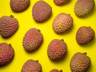 Lychee on the table. Chinese plum on a yellow background. Ripe fruit from Asia.