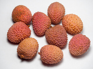 Lychee on the table. Chinese plum on a white background. Ripe fruit from Asia. Delicious, juicy product.