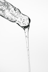 Transparent pipette with cosmetics on a white isolated background.