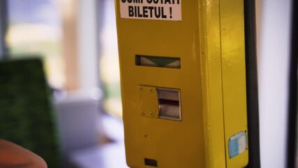 A woman validates two paper tickets on a bus, close up, selective focus