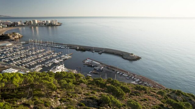 drone flight view of a Small sports nautical club showing several mooring rows with dozens of docked recreational boats next to each other in Oropesa Del Mar, Spain