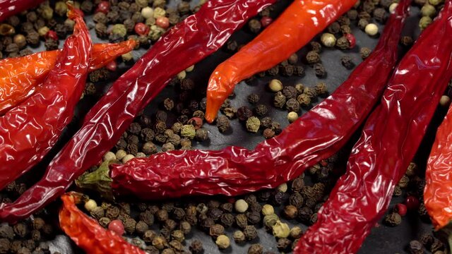Dried red hot chili peppers with mixed peppercorns rotation background. Close up