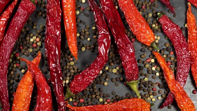 Dried red hot chili peppers with mixed peppercorns rotation background. Close up