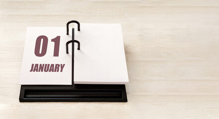 january 1. 1th day of month, calendar date. Stand for desktop calendar on beige wooden background. Concept of day of year, time planner, winter month