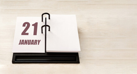 january 21. 21th day of month, calendar date. Stand for desktop calendar on beige wooden background. Concept of day of year, time planner, winter month