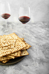 Jewish ritual passover treat traditional matzah bread and red wine in glasses. Gray marble background. Jewish Passover, traditions, rituals, religion, kosher food, menu design.