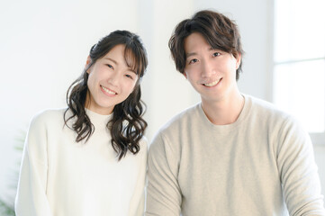 Portrait of young Asian couple looking at camera, copy space 