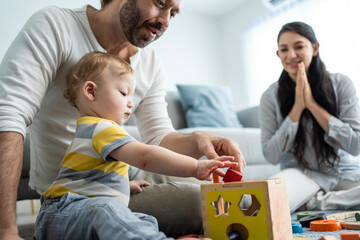 Caucasian happy loving parent play with baby toddler in living room. 