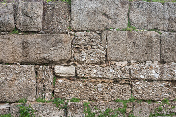 Background of brown-gray stone wall with leaves and moss . Pattern of slate wall texture and background
