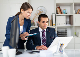 Fototapeta premium Head gives task to assistant at office at table