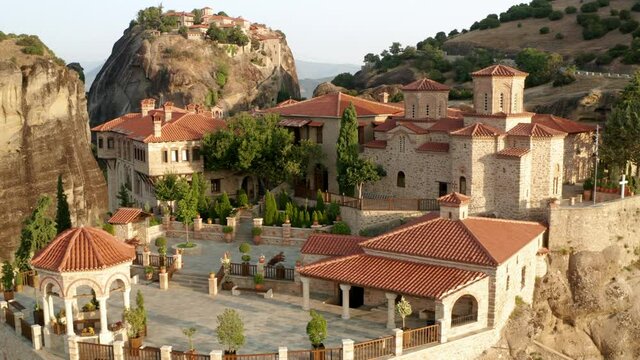 Monastery of Varlaam On Clifftop In Meteora During Sunrise In Greece. Aerial, Close up