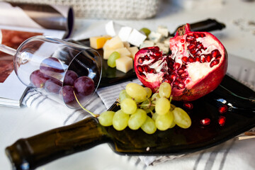 Cheese platter with different cheese and grapes, served on a glass transparent dish from a melted bottle