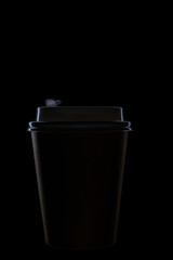 Illuminated edges of silhouette of disposable cup on black background, for hot coffee and hot drinks.