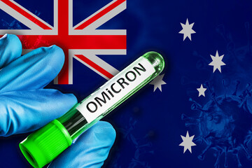 Australia outbreak of omicron variant. Hand holds a test tube with covid-19 virus omicron in front...