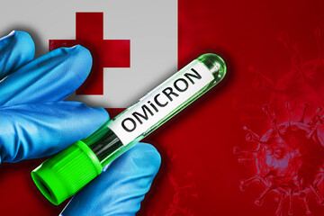 Tonga outbreak of omicron variant. Hand holds a test tube with covid-19 virus omicron in front of...