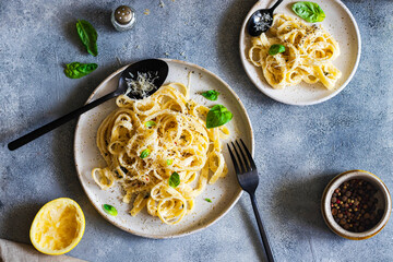 vegetarian pasta  with lemon, basil, parmesan and black pepper searved on a gray stone background....