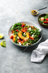 salad bowl with arugula, strawberry, cottage cheese, nectarine and peanut paste. healthy eating concept