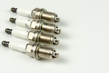 A set of new car spark plugs as a spare part of motor vehicles on white. Group of candles for the engine close-up. Copy space