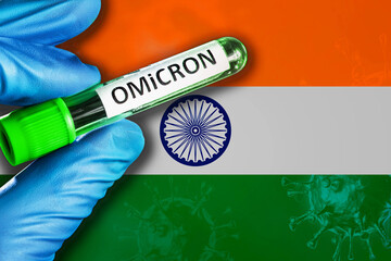 India outbreak of omicron variant. Hand holds a test tube with covid-19 virus omicron in front of...