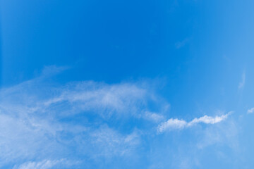Beautiful clear blue high sky with light fluffy clouds far away on wonderful sunny bright day of summer holiday