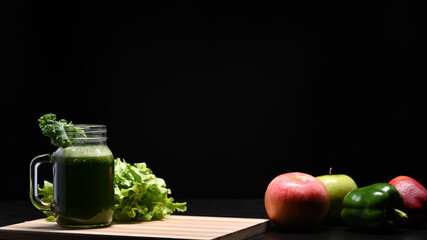 Homemade green smoothie in glass jar on wooden table. Vegetarian food concept.