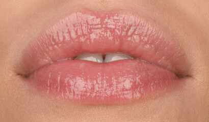 Fototapeta premium Sensual woman with sensual lips with balm. Close-up perfect natural lip, female mouth. Plump sexy full lips. Macro face detail. Beauty and fashion.