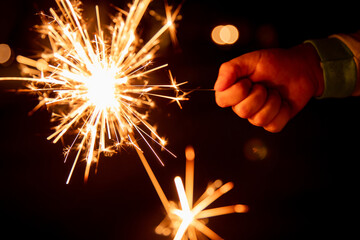 A child holds a sparkler to celebrate