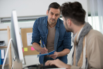 teacher checking students work on computer screen