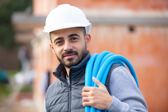 construction worker on site holding pipe