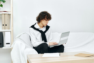 teenager laptop sitting on white sofa online training living room
