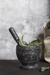 Food background with spices with copy space. Dried bay leaf in a mortar and linen bag on a kitchen countertop