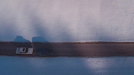 Older car being towed on a trailer by a modern van. Visible shadow on the ground for a cool...