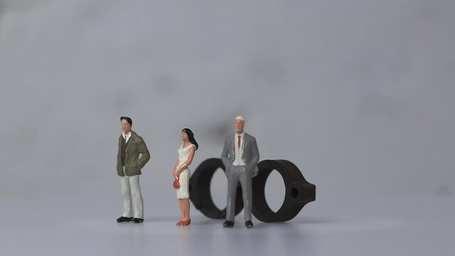Concept of prejudice against social gender. Miniature people and miniature glasses.
