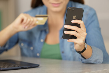 young woman using credit card to pay for online purchase