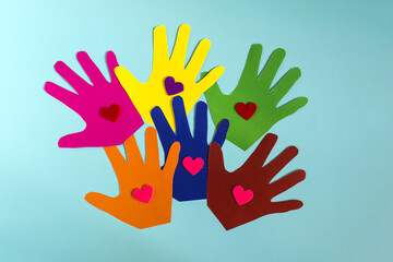 Fototapeta premium Abstract background colored paper children's palms with hearts on a colored background.