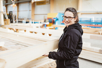 Happy femaleworker in a woodworking factory or workshop