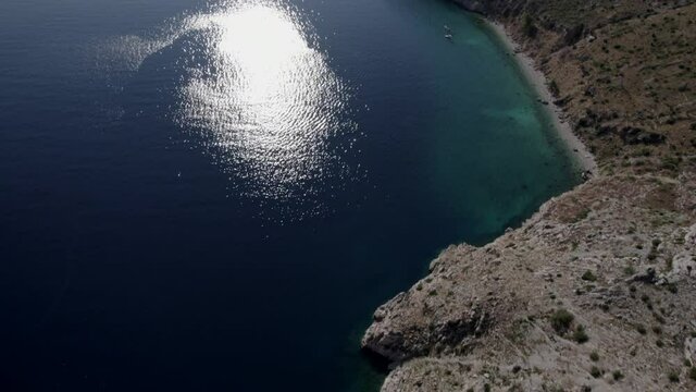 Video with Drone over the Vruja beach on the Croatian coast in the Makarska Rivera, Zadvarje beach with boats is seen in the background. Descriptive front plan.
