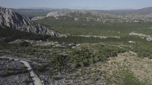 Video with Drone over the mountains of the Makarska Riviera in Croatia with Wind Power Windmills in the background. Ascending plane of a descriptive crane ending in the Horizon.
